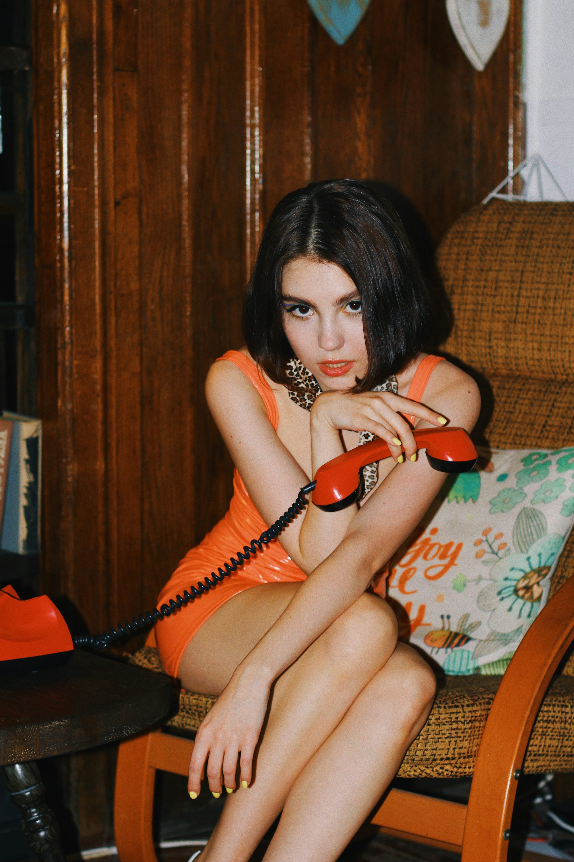 a woman sitting on a chair with a telephone in her hand