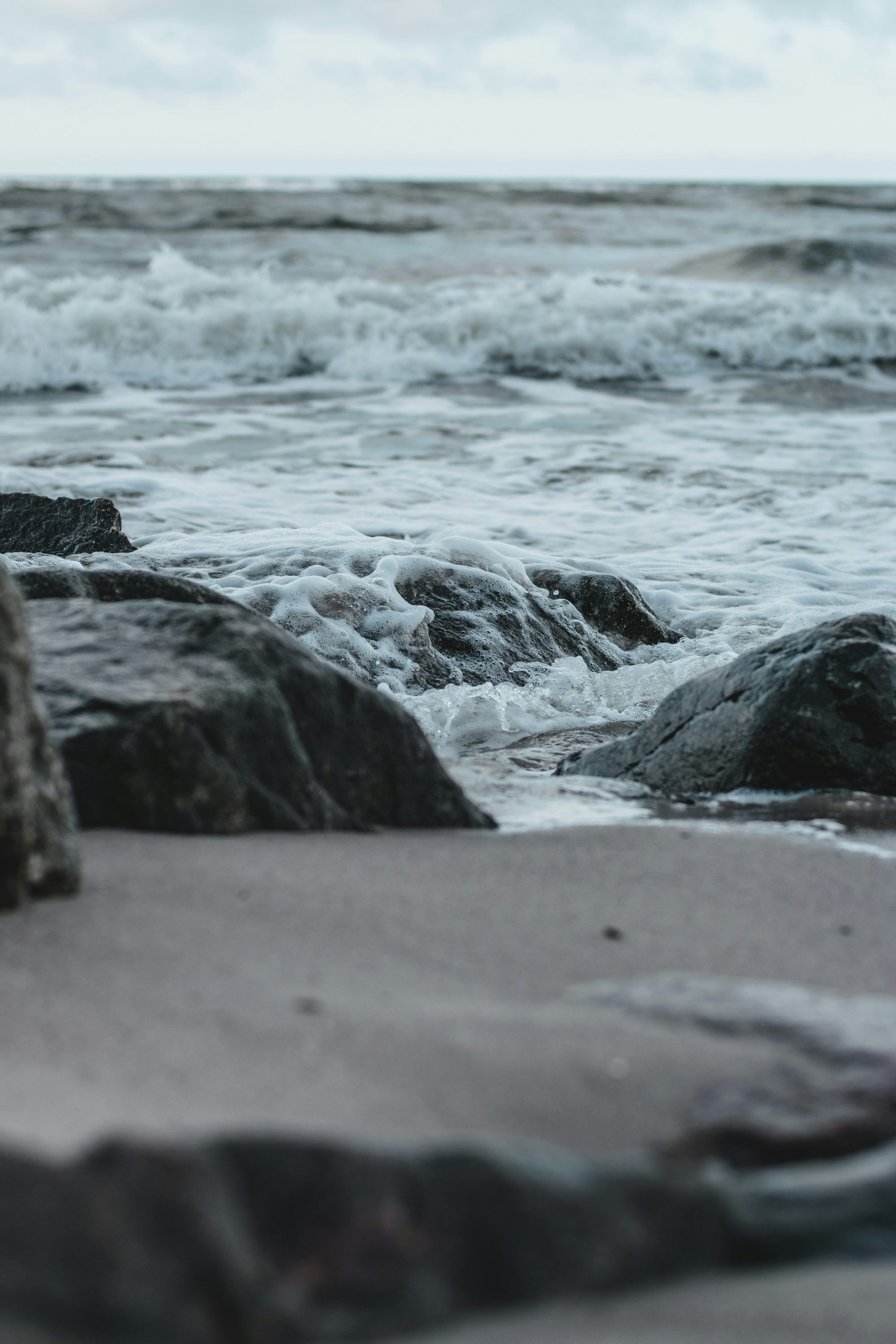 gray rocky shore with water waves during daytime